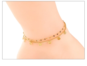 Detail of double-layer gold anklet featuring minimalist chains and happy smiley face charms
