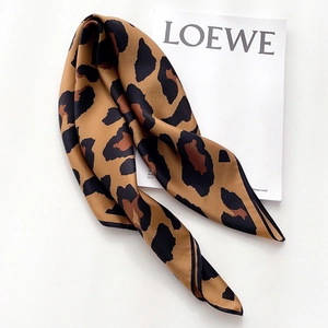Chic leopard print silk scarf with satin finish displayed on a white magazine