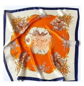 Macro shot of silk square scarf featuring baroque patterns in orange and navy blue