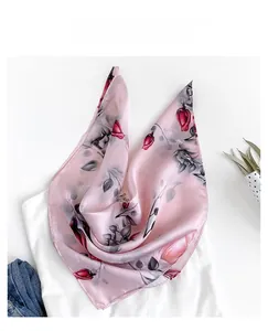 Detailed view of pink silk satin scarf with red tulip prints and delicate rolled edges