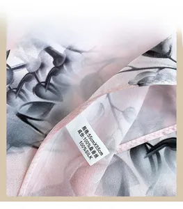 Detail of 100% mulberry silk scarf showing machine-hemmed edges and floral pattern