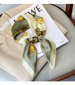 Detailed view of square silk scarf with gold baroque carriage print and mint green base