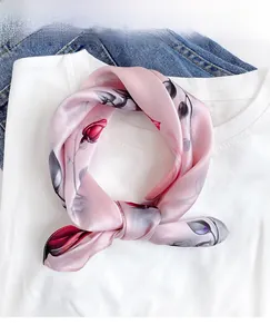 Detailed close-up of pink mulberry silk scarf with red rose pattern on a white t-shirt