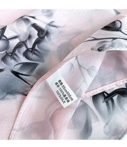 Detail of 100% mulberry silk scarf featuring a plant leaf pattern and 55x55cm label