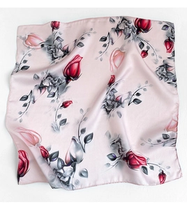 Detailed close-up of pink mulberry silk scarf with vibrant rose pattern and rolled edges