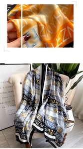 Détail d'un foulard en satin à motif de lettres avec texture douce sur une chaise