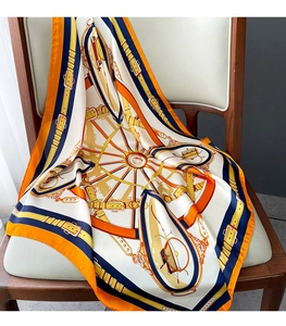 Détail d'un grand foulard en soie avec imprimés équestres sur une chaise en bois moderne
