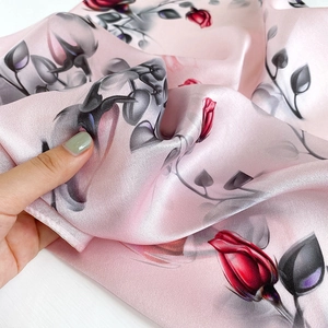 Pink mulberry silk scarf featuring realistic red and black rose prints and a glossy finish