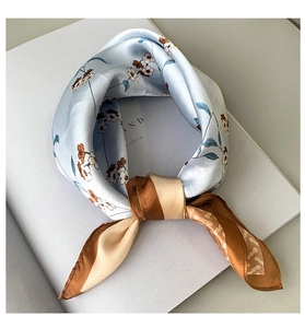 Detail of light blue floral silk neckerchief with elegant brown borders on magazine