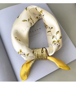 Detail of silk-texture floral scarf with yellow border on a grey magazine background
