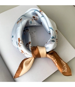Detailed view of floral silk neckerchief with elegant blue pattern and contrast borders