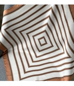 Close-up detail of mulberry silk scarf with brown and black geometric square pattern
