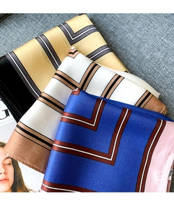 Macro detail of silk scarves with classic geometric patterns and smooth satin finish