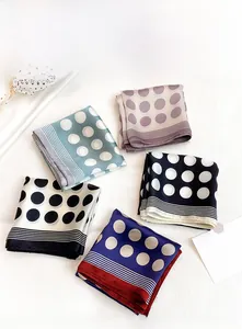Close-up of elegant polka dot silk scarves folded on a white textured background