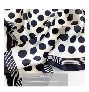 Detailed close-up of premium silk scarf featuring classic polka dots and machine hemmed edges