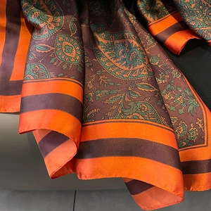 Macro detail of paisley pattern silk-like scarf with satin finish and elegant drapes