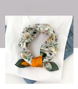 Détail d'un foulard en soie à motif marguerites sur t-shirt blanc et tissu denim