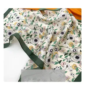 Détail d'un carré en soie de mûrier à imprimé floral avec bordure vert foncé