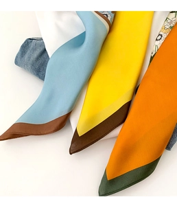 Gros plan détaillé de foulards en soie à fleurs bleu jaune et orange en satin brillant