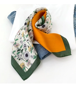 Détail d'un foulard en soie à fleurs avec des blocs géométriques jaune et vert
