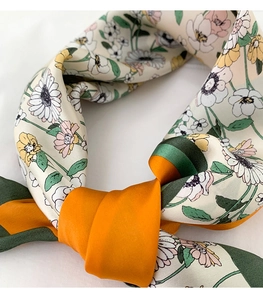 Vue détaillée d'un foulard en soie à motif floral avec des bords contrastés