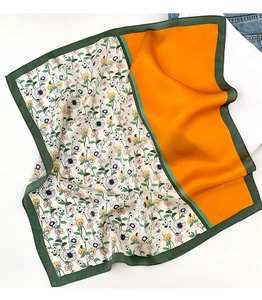 Gros plan sur un foulard en soie avec épissure orange et motifs floraux vintage