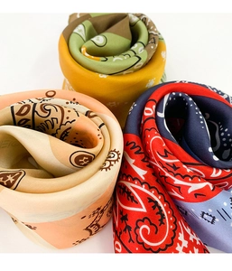 Close-up of three silk-like scarves with paisley and bohemian patterns in vibrant colors
