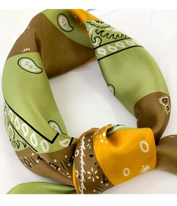 Detail of silk satin scarf with green and brown paisley print and geometric patterns