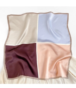 Dettaglio del foulard quadrato in raso a quattro colori su camicia bianca