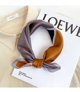 Dettaglio ravvicinato di un foulard in seta con motivi geometrici e finitura satinata
