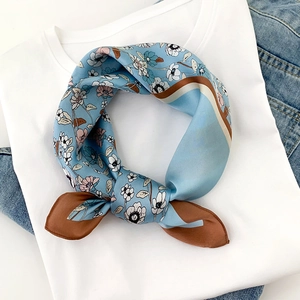 Foulard en soie bleu à motifs floraux sur un t-shirt blanc et fond en denim