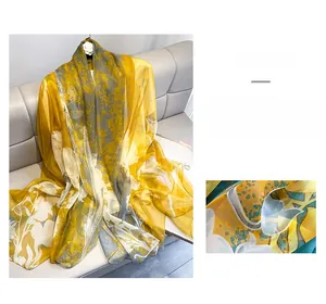 Macro detail of lightweight floral chiffon scarf with elegant yellow and grey prints