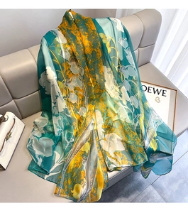 Artistic floral silk scarf with bellflower print draped elegantly on a beige sofa
