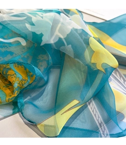 Detail of floral chiffon scarf showing soft translucent texture and blue-yellow print