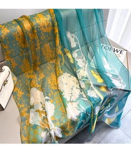 Detail of floral silk scarf draped on chair showing soft texture and vibrant prints