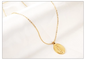 Détail du pendentif Marie plaqué or 18K sur chaîne croisée avec fond en satin doux