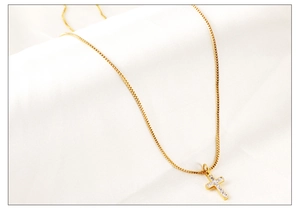 Détail du pendentif croix avec zircons blancs sur chaîne box plaquée or 18 carats
