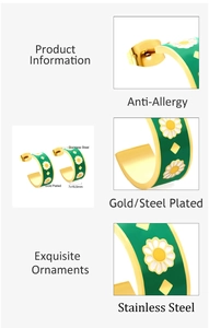 Detail view of gold-plated stainless steel C-shape earrings with green enamel and daisies