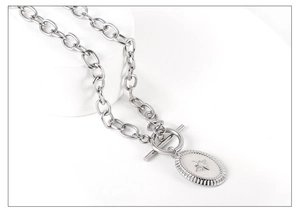 Macro view of silver stainless steel necklace featuring a starburst oval pendant and OT toggle clasp