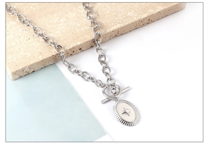 Detail of silver oval sun star pendant on thick chain with vintage OT toggle clasp