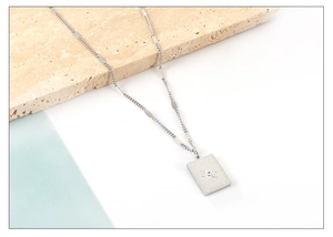 Detailed macro view of silver celestial necklace with sunburst pendant and crystal inlay