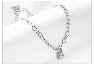 Macro detail of silver padlock pendant with sparkling rhinestones on chunky chain