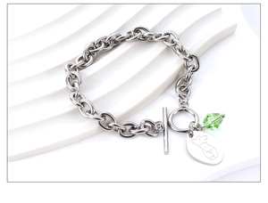 Details eines silbernen OT-Verschluss-Armbands mit grünem Kristall und Kunstanhänger