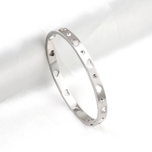 Polished silver heart hollow bangle with inlaid crystals on white silk background