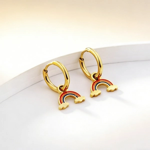 Detailed close-up of golden rainbow hoop earrings on a minimalist display stand