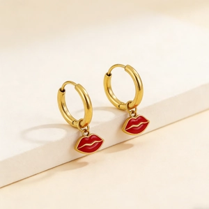 Chic gold hoop earrings with red lip pendants on minimalist white display stand