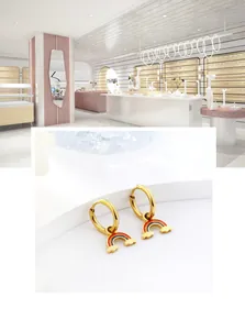 Detailed macro view of gold hoop earrings featuring enamel rainbow and cloud charms