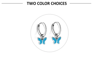 Detailed macro view of silver butterfly hoop earrings with blue enamel wing patterns