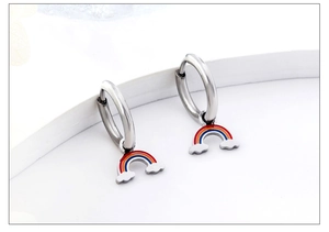 Detail of rainbow hoop earrings with colorful enamel charms on a white display
