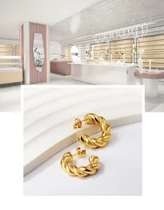 Macro detail of 18K gold plated C-shaped twisted hoop earrings with a polished spiral design